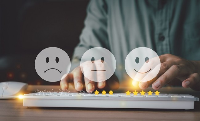 Das Bild zeigt zwei Hände an einer Tastatur und drei Smileys mit verschiedenen Ausdrücken.